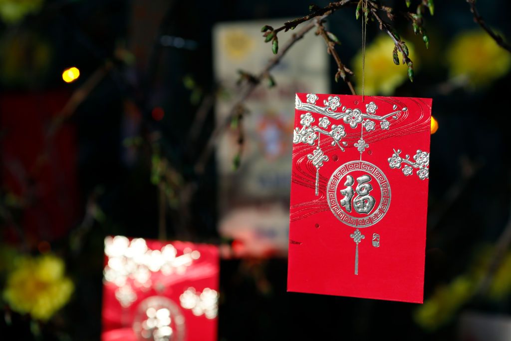 Red envelope ( hongbao ) on yellow tree for Chinese and Vietnamese New Year. Red color is a symbol of good luck. France. (Photo by: Philippe Lissac/Godong/Universal Images Group via Getty Images)