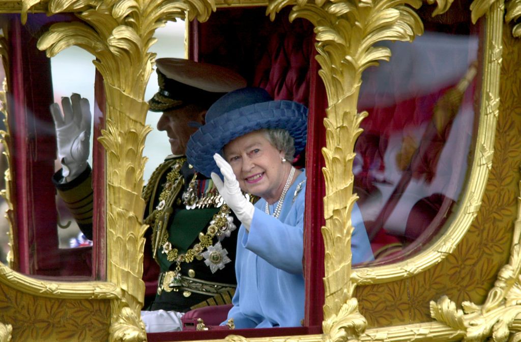 Britain's Queen Elizabeth II waves to the crowd as she rides in the Gold State coach from Buckingham Palace to St Paul's Cathedral for a service of Thanksgiving to celebrate to her Golden Jubilee. (Photo by Rebecca Naden - PA Images/PA Images via Getty Images)