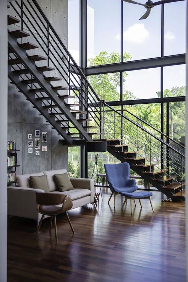 The double-height living room offers a generous view of lush surroundings