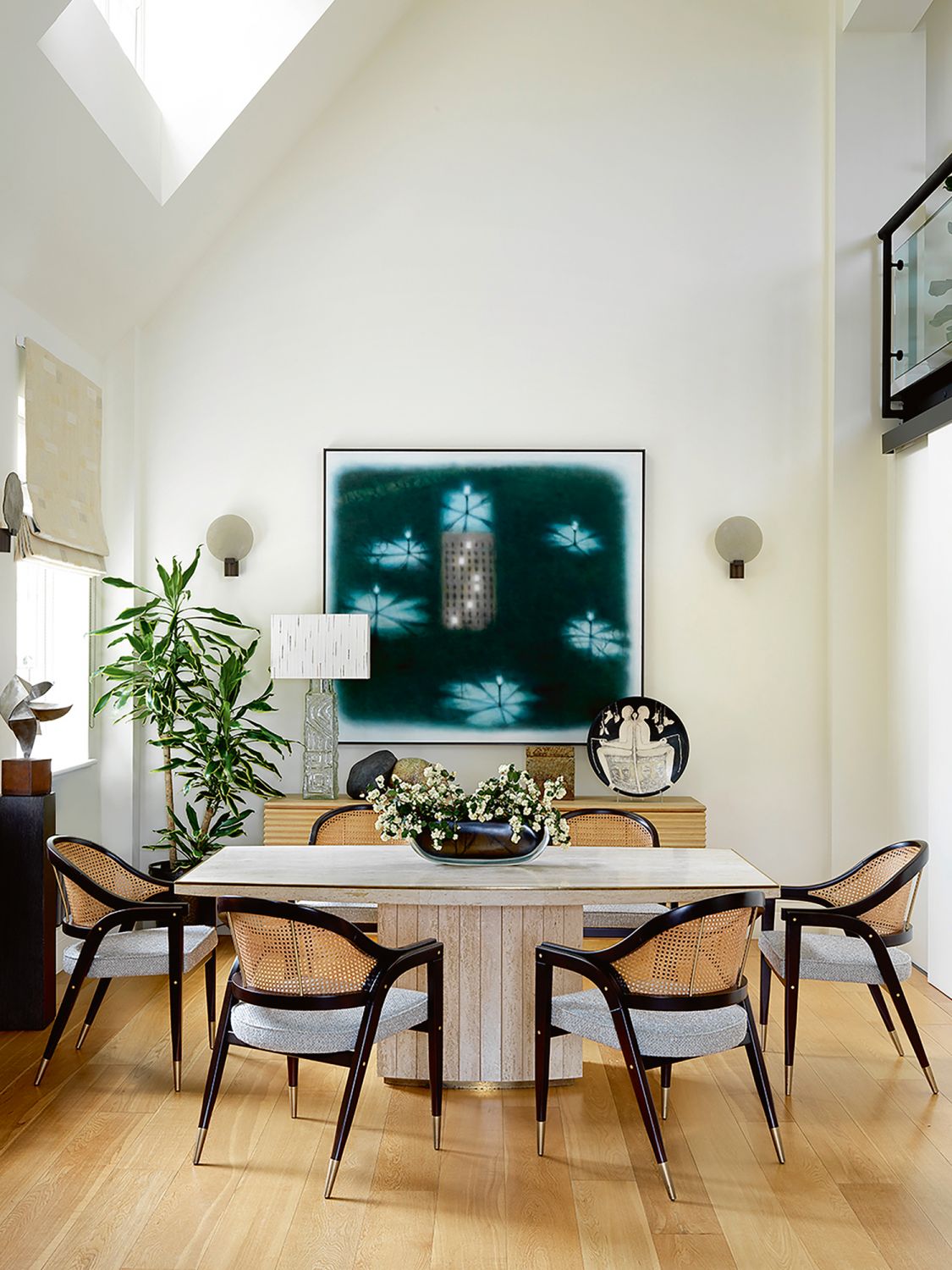 Off-white walls and light wood flooring are a restful canvas for the colourful artworks and furnishings in the home