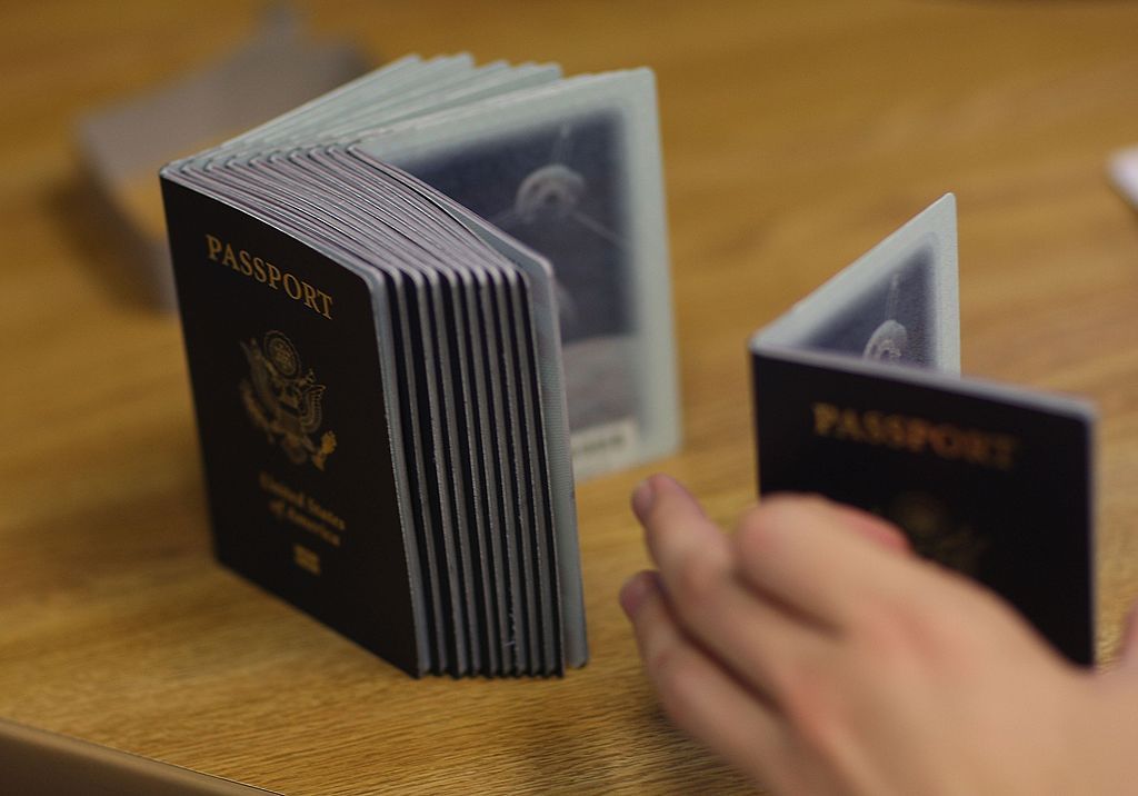 MIAMI - JUNE 22: A Passport Processing employee uses a stack of blank passports to print a new one at the Miami Passport Agency June 22, 2007 in Miami, Florida. The Bush administration postponed for at least six months a requirement that Americans who return to the United States by land or sea from Canada, Mexico and the Caribbean must carry passports. The rule, due to go into effect in January 2008, will be delayed until the summer of that year. (Photo by Joe Raedle/Getty Images)