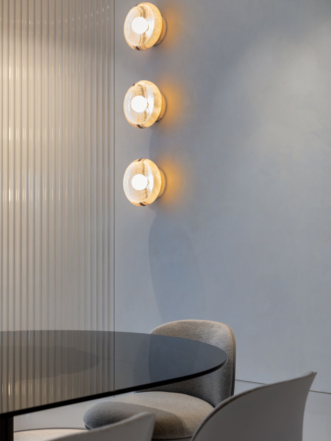 The living and dining spaces feature black and white onyx wall sconces from Piedra Collection
