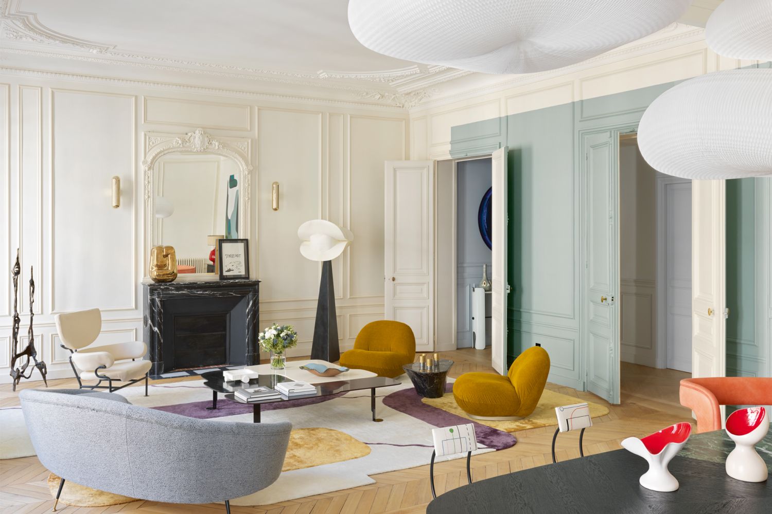 The living area is furnished with a vintage sofa from Glustin Gallery, a Tre Pezzi armchair by Franco Albini, Gubi Pacha armchairs by Pierre Paulin and a custom coffee table and rug designed by Le Berre Vevaud