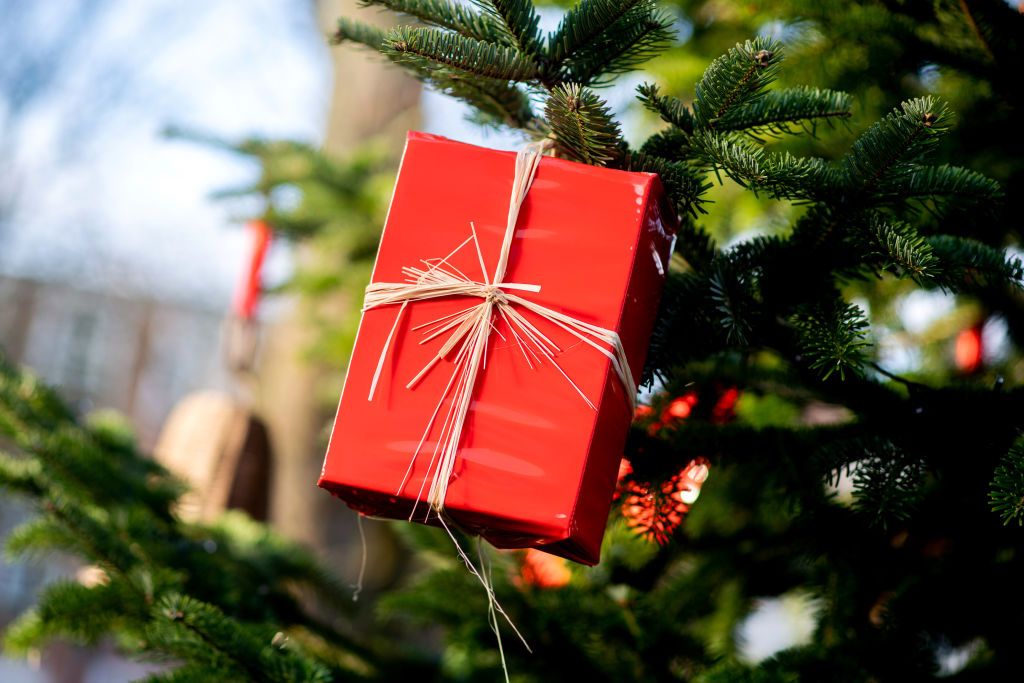 15 December 2021, Lower Saxony, Greetsiel: A red present hangs on a fir tree in the center of town. Photo: Hauke-Christian Dittrich/dpa (Photo by Hauke-Christian Dittrich/picture alliance via Getty Images)