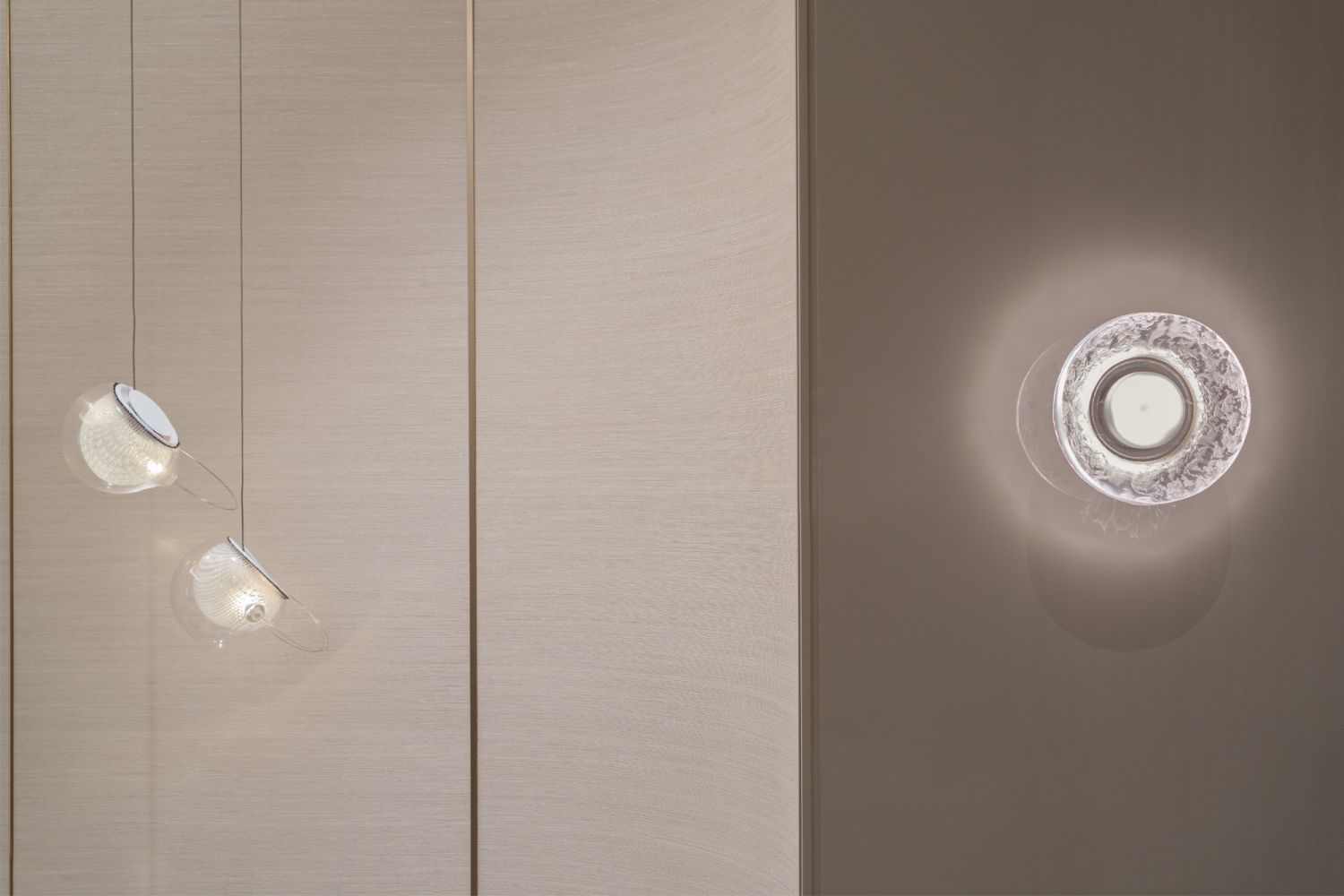 The 76.1 pendant lights by Bocci are paired with the Retina White cast glass wall scone by Garnier and Linker