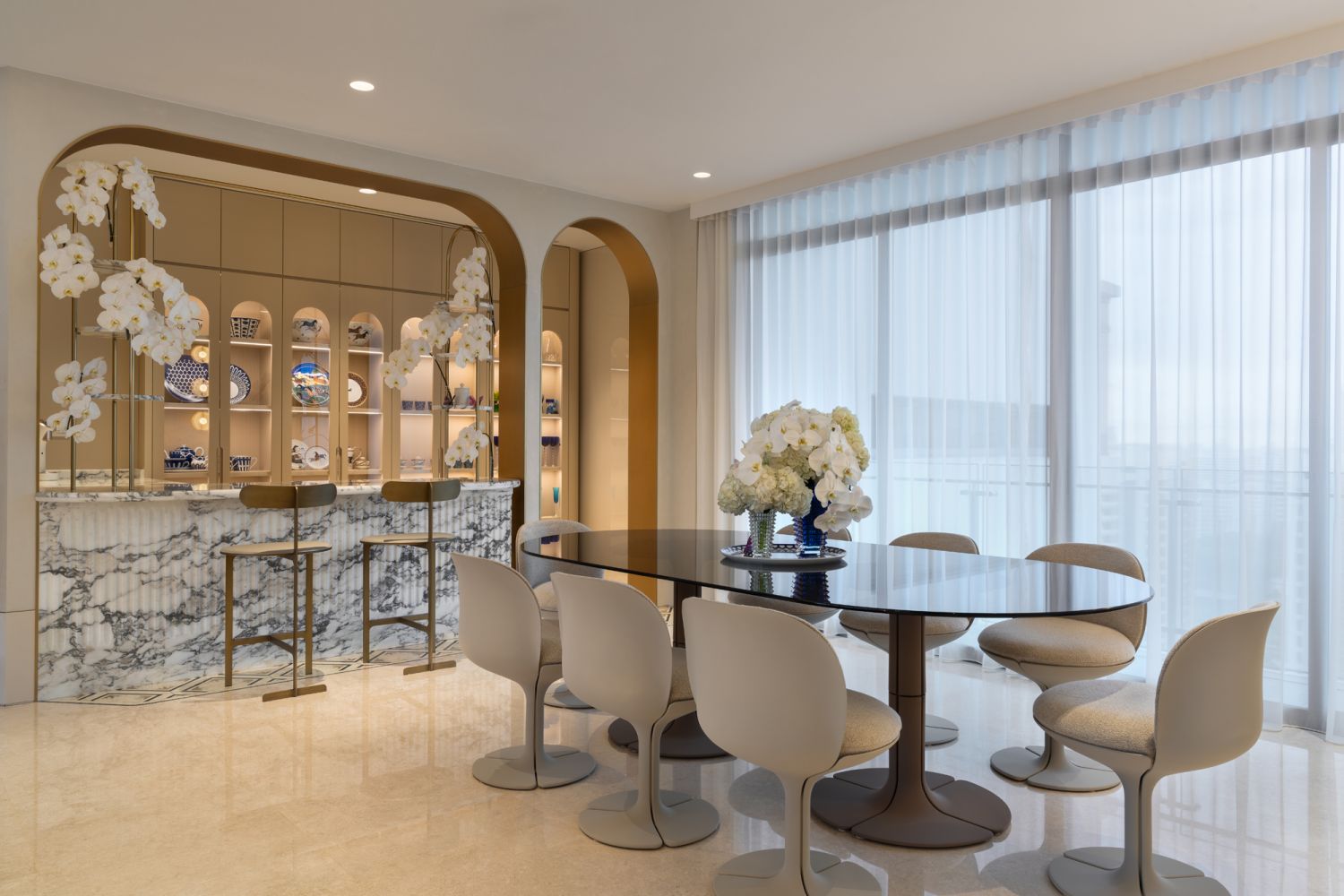The dining area is an ode to elegance with brass details and marble accents