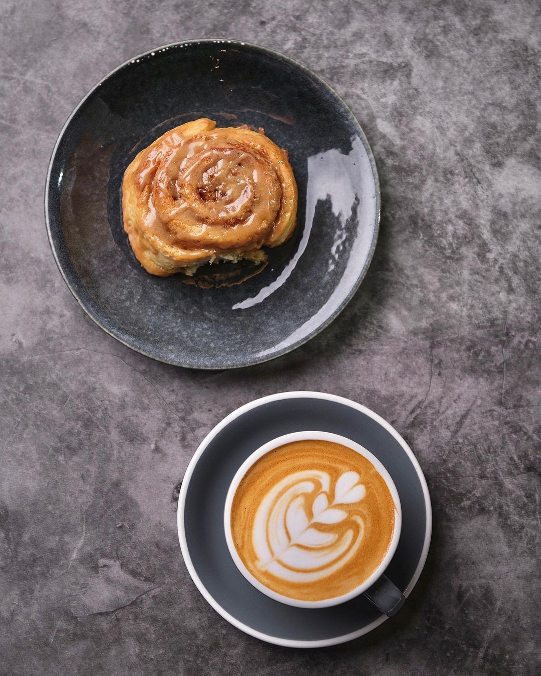 Orange sticky bun and a cup of coffee from Caravan Black | Photo by Hans Fausto, courtesy of @caravanblack/Instagram