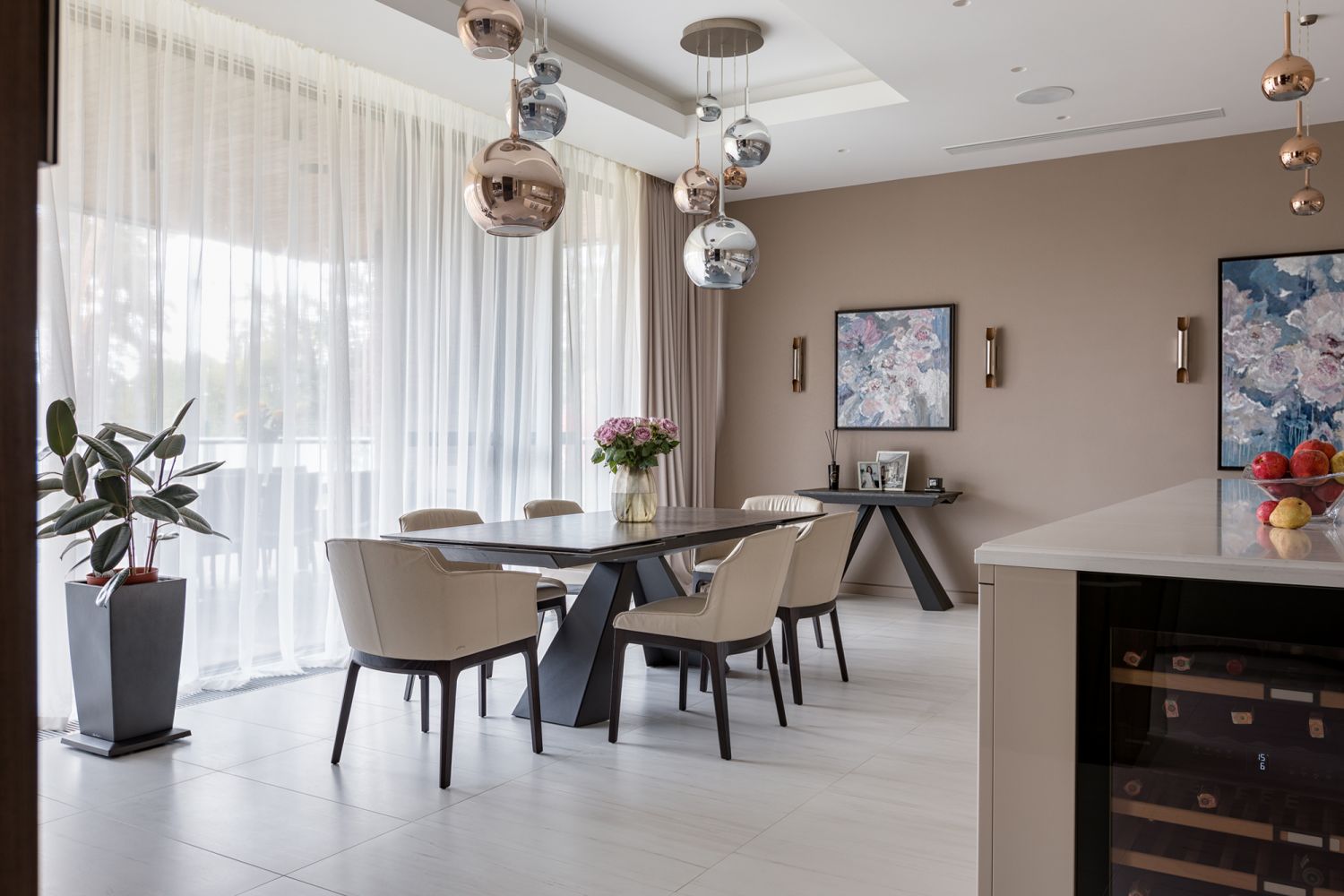 The dining area is enlivened with delicate prints by Ukraine artist Mariia Vozvyshaieva