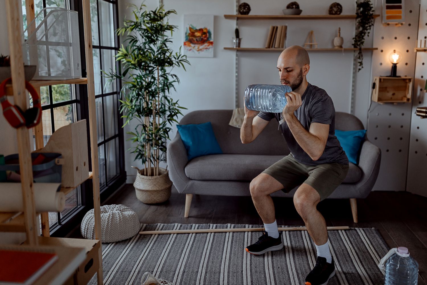 Young man exercising with a gallon of water at home