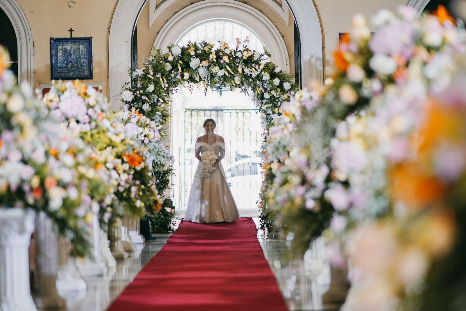 The happy bride walking down the aisle in a gown by Maureen Disini