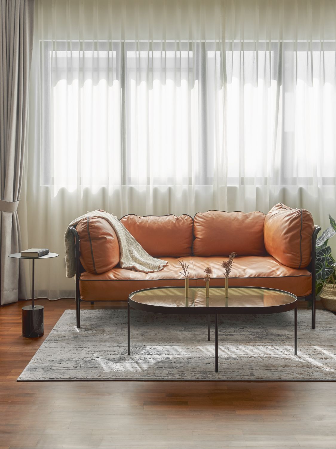 A leather sofa and grey rug invite lounging in the family room