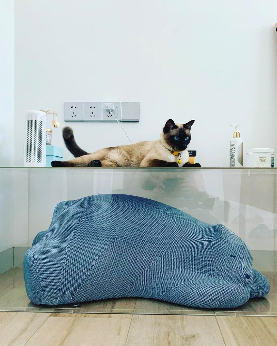 A blue knitted Resting Bear at the base of a bedside table (Image: Vitra)