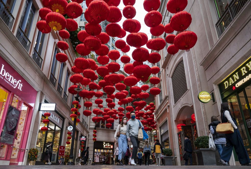 HONG KONG, CHINA - JANUARY 28: Pedestrians walk through a street with red lanterns hanging from the ceiling to celebrate the upcoming Chinese Lunar New Year of the Tiger in Hong Kong on January 28, 2022. (Photo by Miguel Candela/Anadolu Agency via Getty Images)