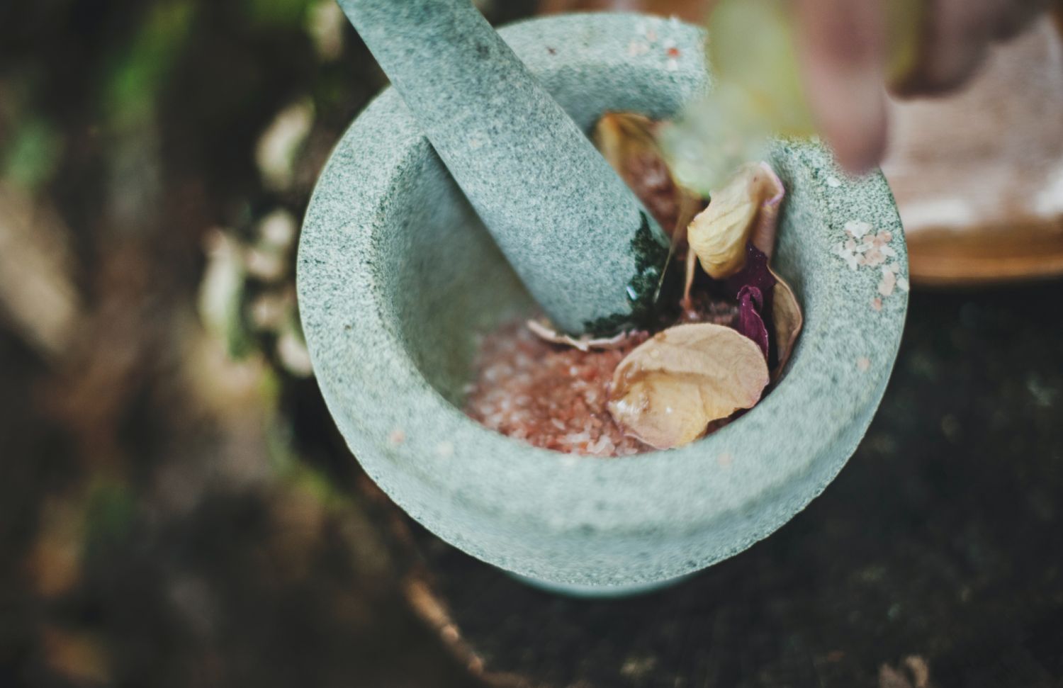 Woman grinding flower petals (Photo: Katherine Hanlon / Unsplash)