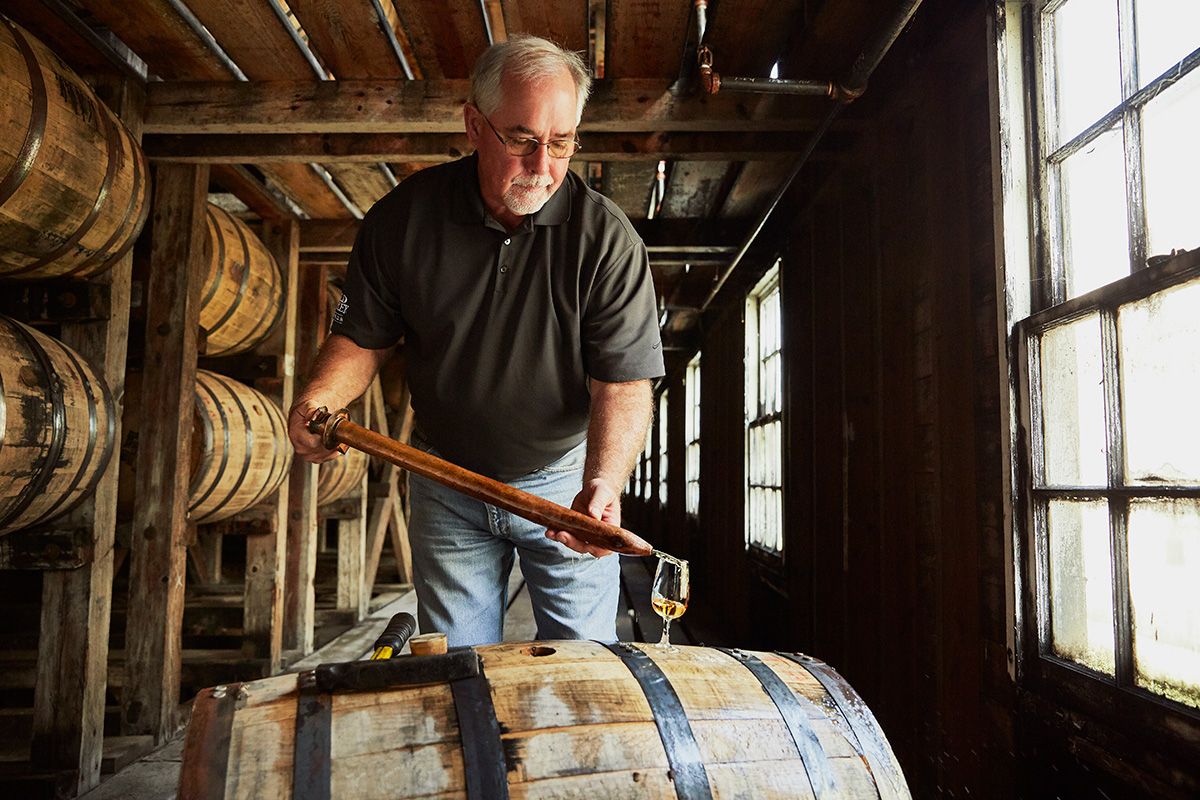 Wild Turkey’s master distiller Eddie Russell extracts the liquid from the barrel