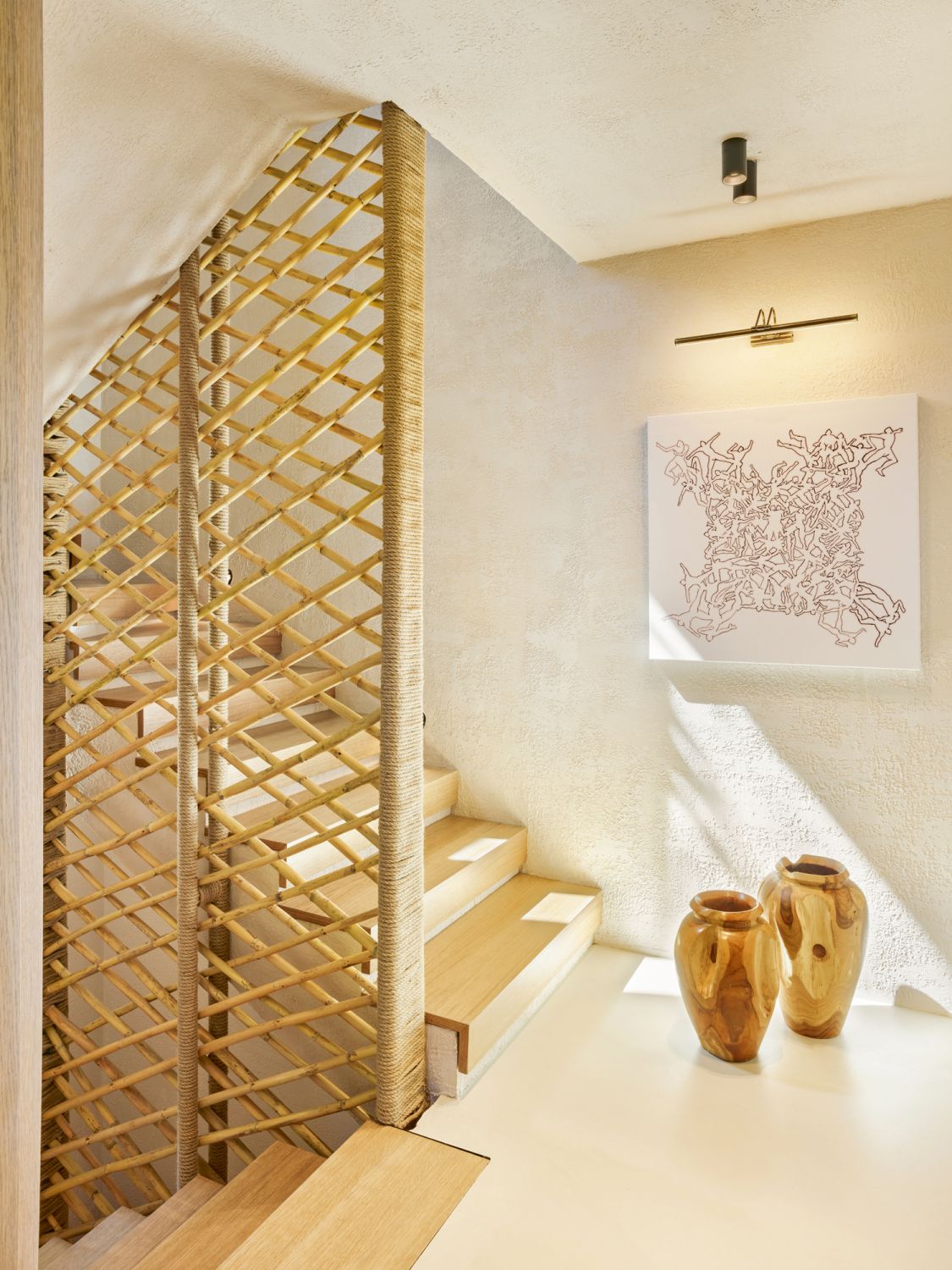 A latticework screen and an artwork create visual interest in the stairwell
