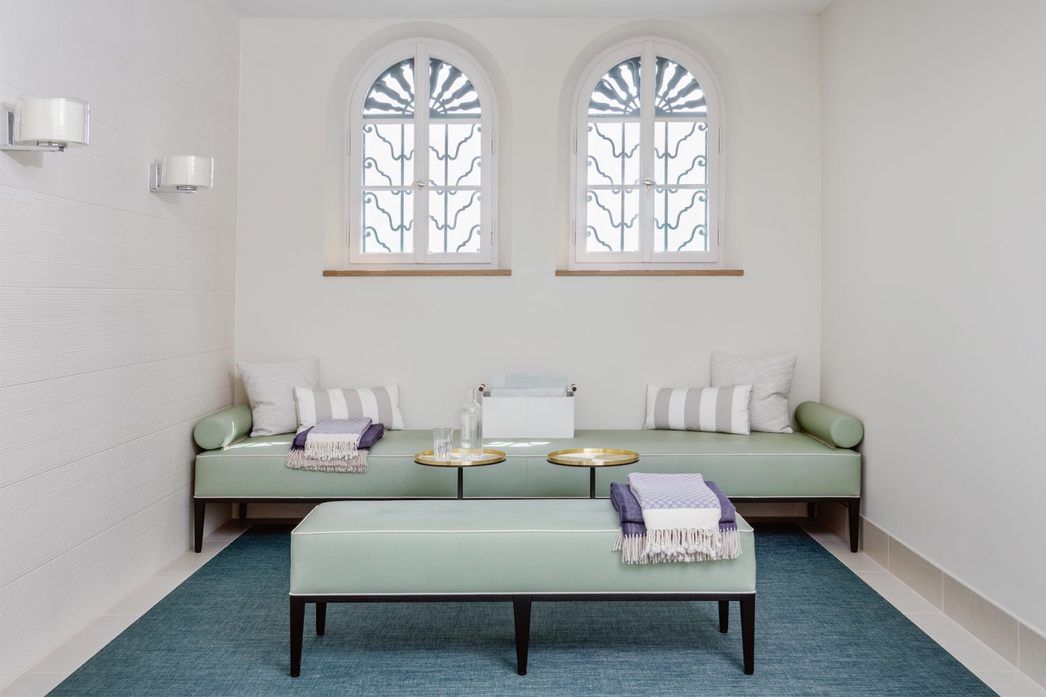 This lounge in the wellness zone of the home is furnished with Marset Mercer wall lights, a custom sofa designed by Ina Rinderknecht and manufactured by Girsberger, and M05 side tables by S+ Systemmöbel