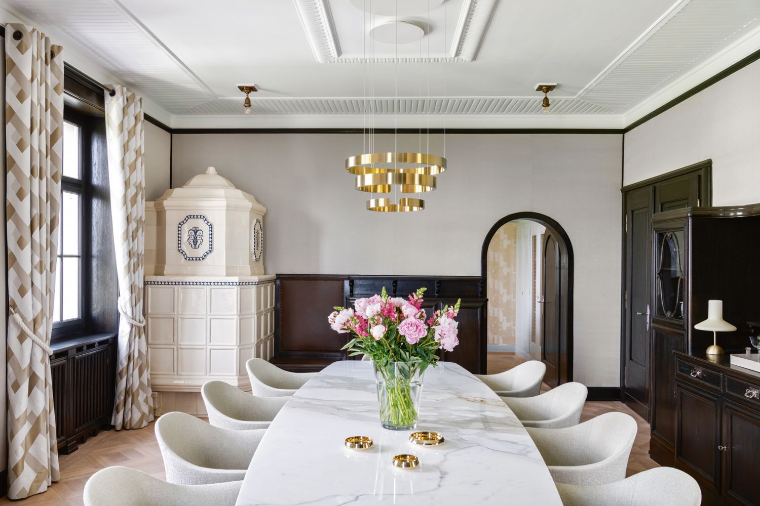 The stately dining room oozes sophistication with its mix of light-hued furnishings and dark wood fixtures