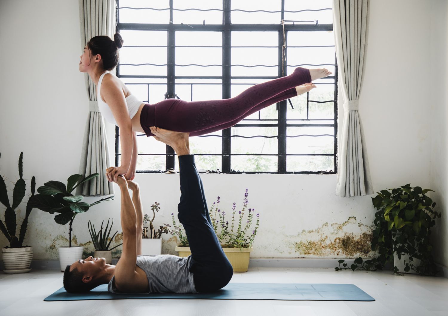 couple practicing acro yoga in a yoga studio