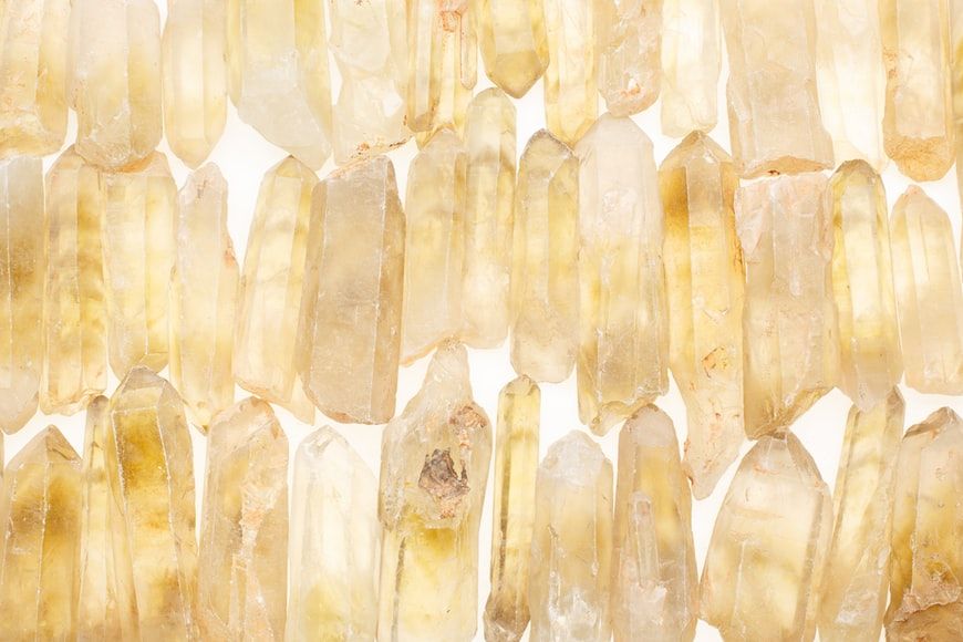 Several rows of large citrine points sit against a white backgroun (Photo: Benjamin Lehman/Unsplash)