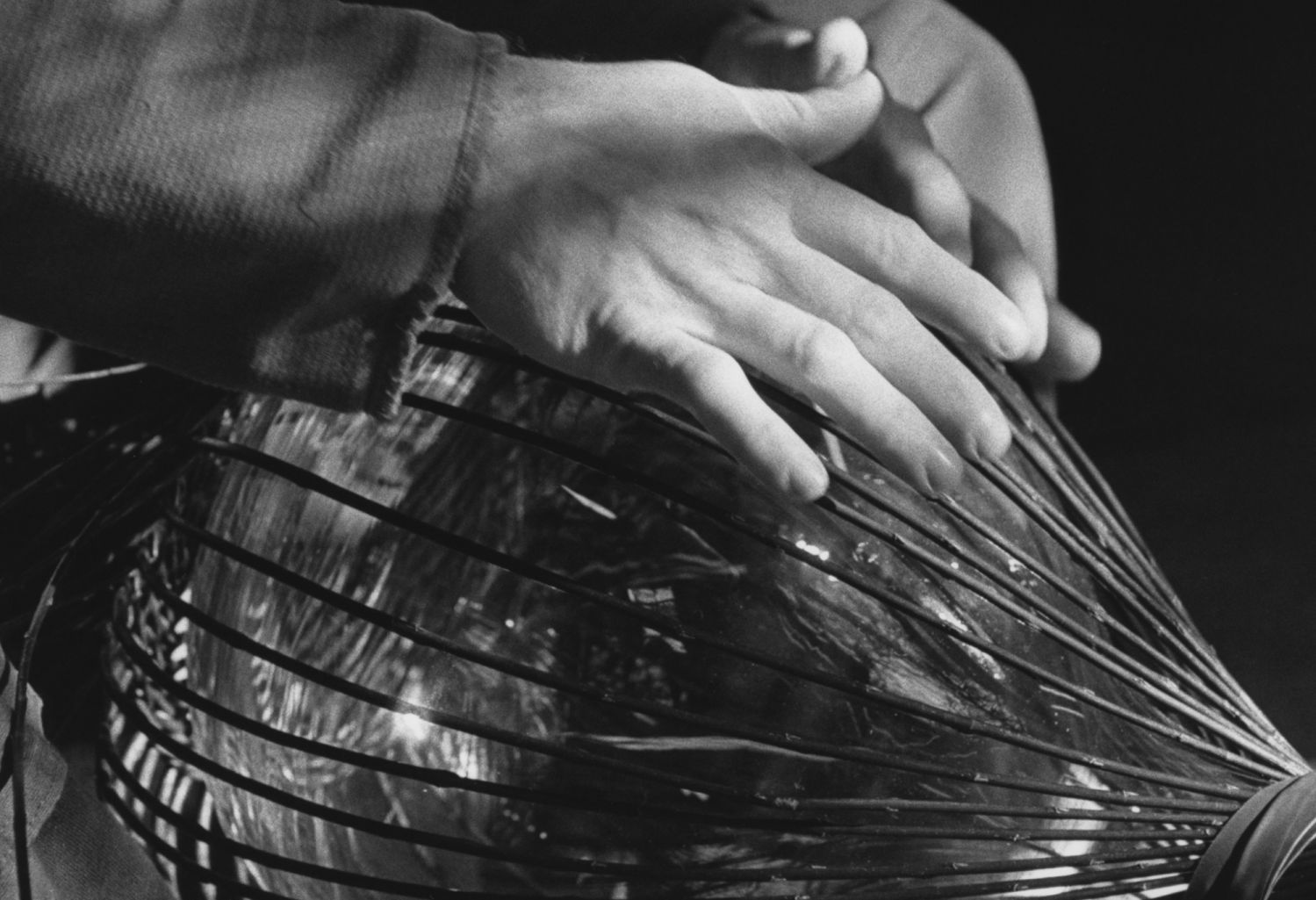 A basket-weaver crafts the willow sculpture that encases the eaux-de-vie
