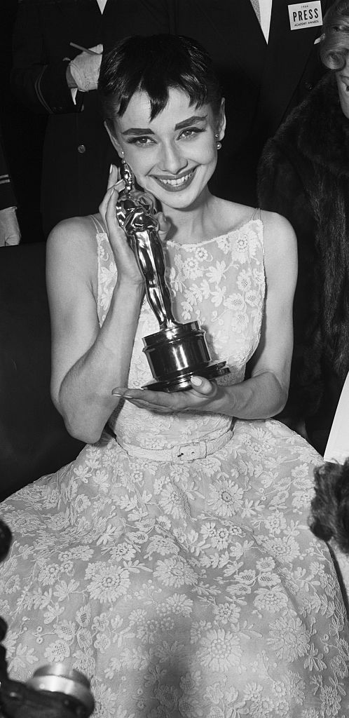 (Original Caption) 3/25/1954- New York, NY: Audrey cuddles up to "Oscar." Audrey Hepburn, who rushed from her hit Broadway play, "Ondine" to receive the Academy Award as "Best Actress" at the Center Theater in New York, cuddles the golden "Oscar" after being presented with the trophy. Audrey won the coveted award for her role in "Roman Holiday" on March 25th.
