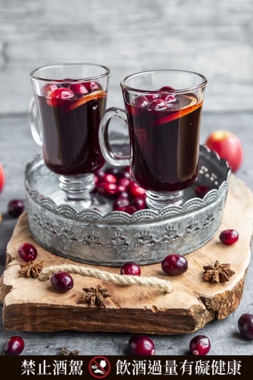 Two glasses of Mulled Wine with cranberries, orange slices and star anise on tray