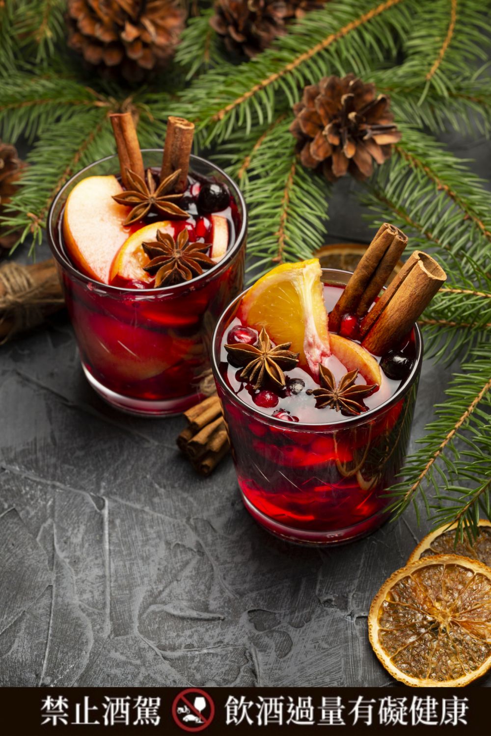 Two Glasses of Christmas Mulled Red Wine with Decoration, Orange, Cinnamon and Fir Tree on rustic background