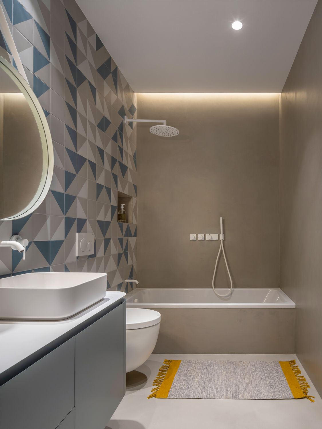 Geometric wall tiles enliven the monochromatic children’s bathroom