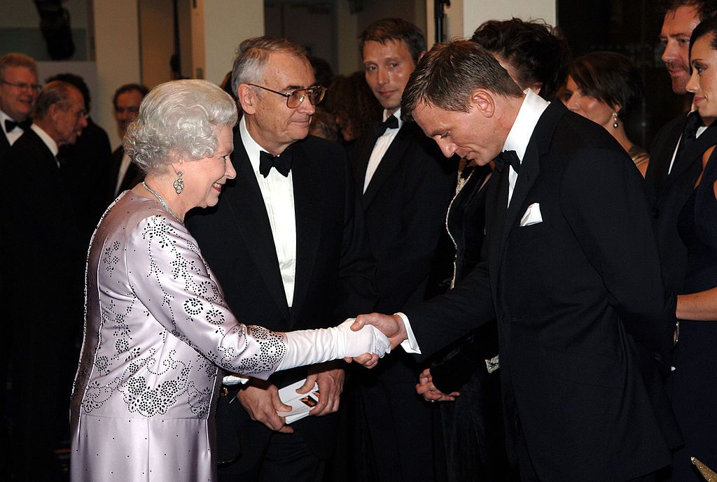 HM Queen Elizabeth II shakes hands with British actor Daniel Craig the new James Bond at the Royal Premiere for the 21st Bond film 'Casino Royale' at the Odeon, Leicester Square on November 14, 2006. (Photo by Anwar Hussein/WireImage)