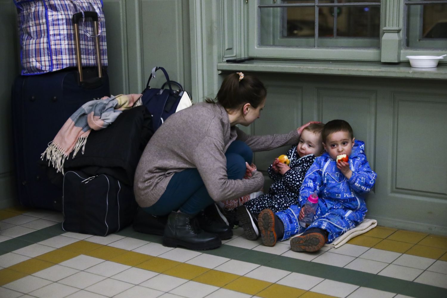 A mother with children is resting in a temporary shelter inside a building of the railway station after arriving on a train from Kiev in Ukraine to Przemysl, Poland on February 24, 2022. Russian invasion on Ukraine can cause a mass exodus of refugees to Poland. (Photo by Beata Zawrzel/NurPhoto via Getty Images)