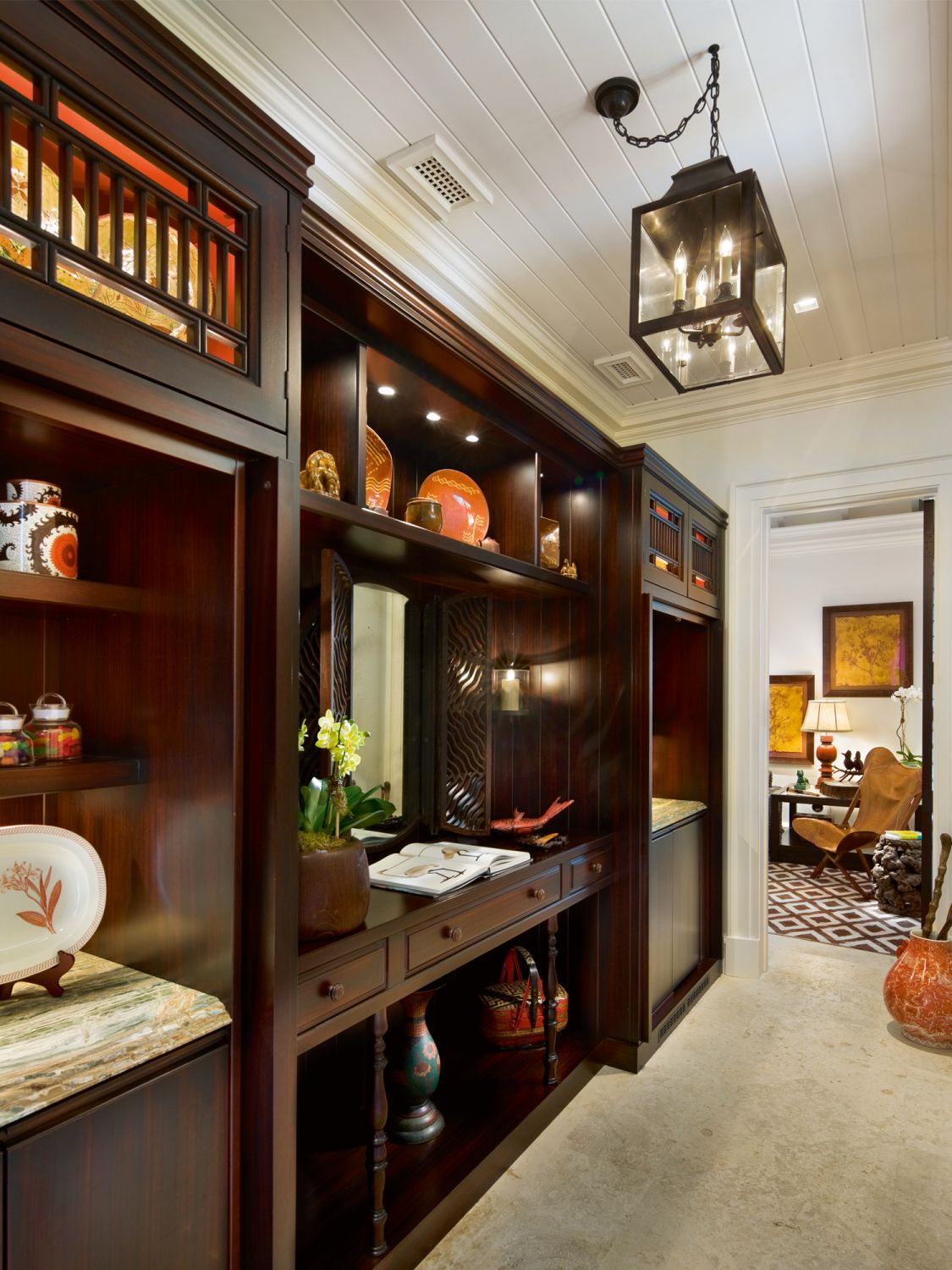 Orange accents invigorate this elegant hallway in the guest cottage