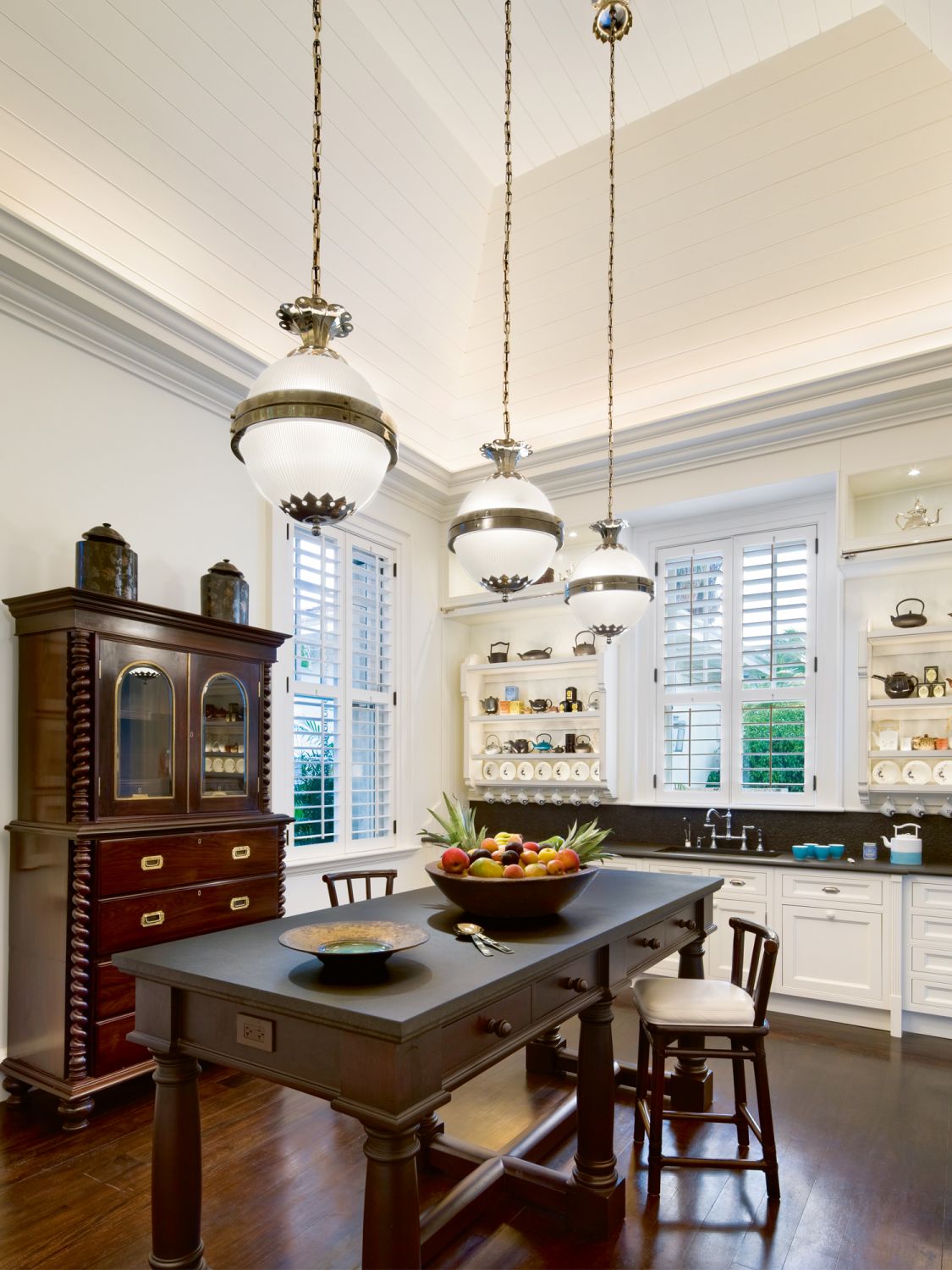 The kitchen is an inviting space with custom teak furnishings and white cabinetry
