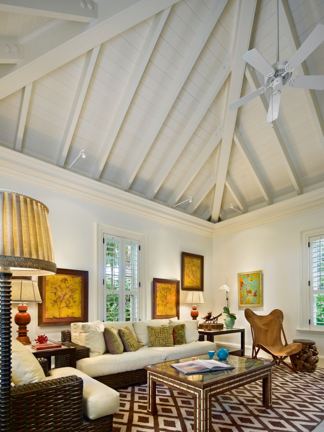 The guest cottage features a double-height living area decorated with furnishings and artwork featuring a mix of Asian influences