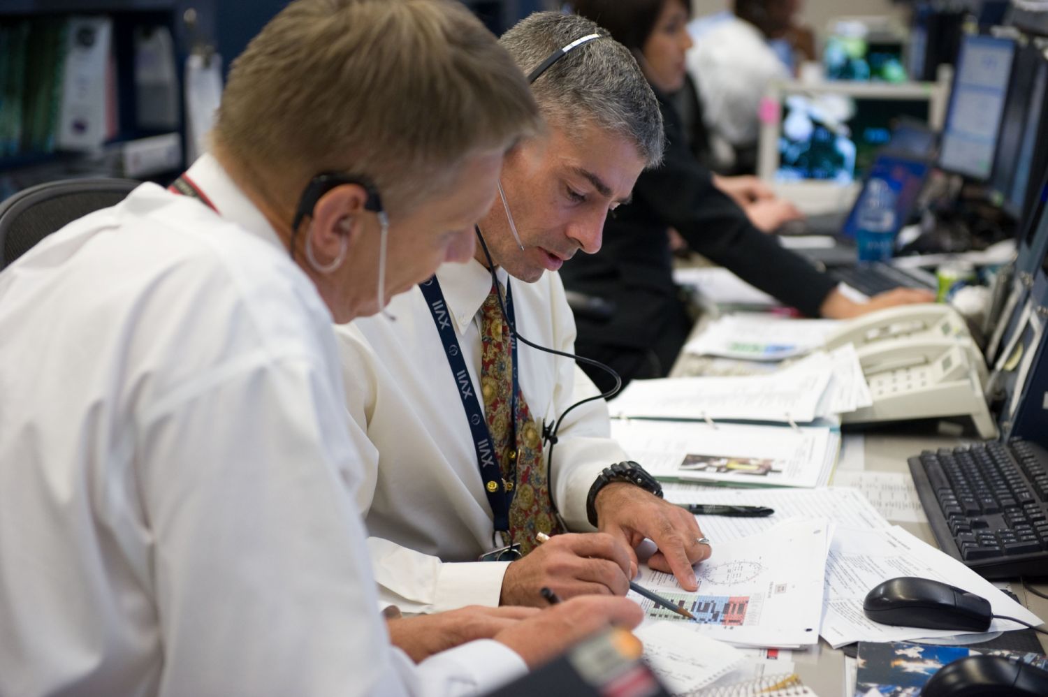 Astronaut Piers Sellers (foreground) and Mark Vande Hei, both ISS Orbit 2 spacecraft communicators (CAPCOM), monitor data at their consoles in the space station flight control room in the Mission Control Center at NASA's Johnson Space Center during the STS-126 mission (Photo: NASA)
