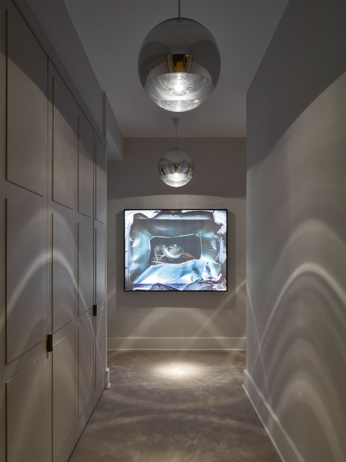 Pendant lamps by Tom Dixon create intriguing light-and-shadow play in the corridor, which also features a JD Staron rug and a video installation