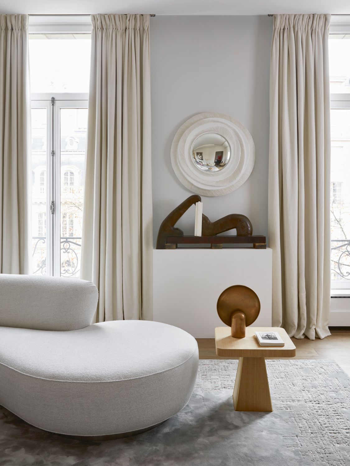 The sofa by Vladimir Kagan features a curvaceous form that echoes the shape of the sculpture