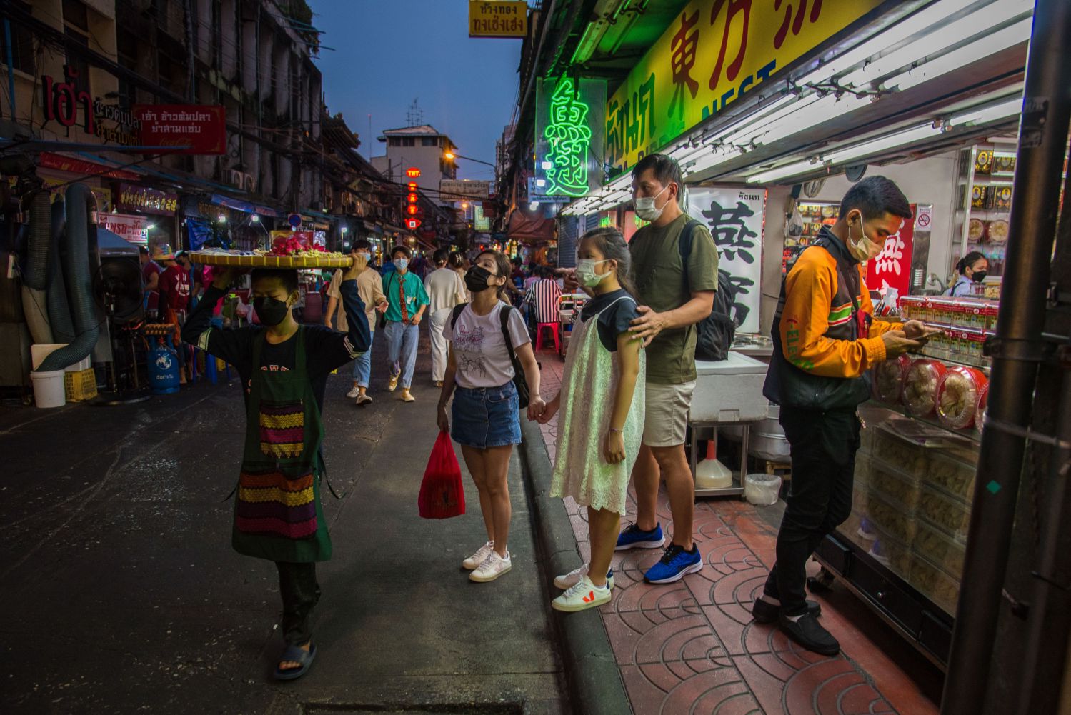 BANGKOK, THAILAND - 2022/03/15: People seen standing in front of a Chinese restaurant at Bangkok's Chinatown. Chinatown also known as Yaowarat is the famous destination for tourists in the night with a lot of the street food stalls and Chinese restaurants. (Photo by Peerapon Boonyakiat/SOPA Images/LightRocket via Getty Images)
