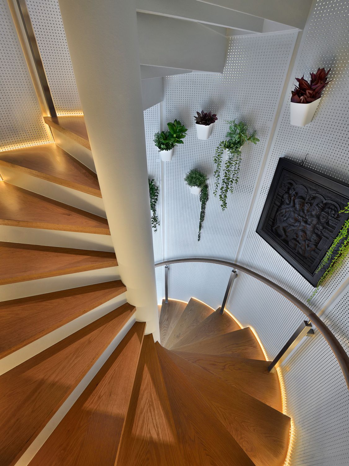 The spiral staircase is thoughtfully designed with touches of greenery