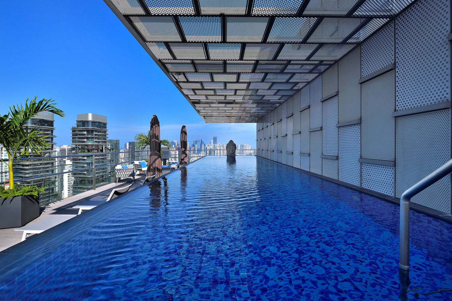 The rooftop pool area features a huge buddha statue on one end