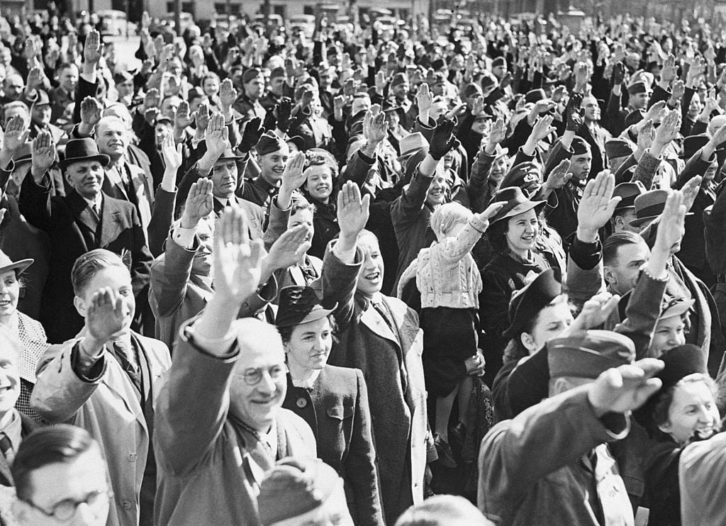 Germans cheer Adolf Hitler on his 51st birthaday as he stands on the balcony of the Reich Chancellory