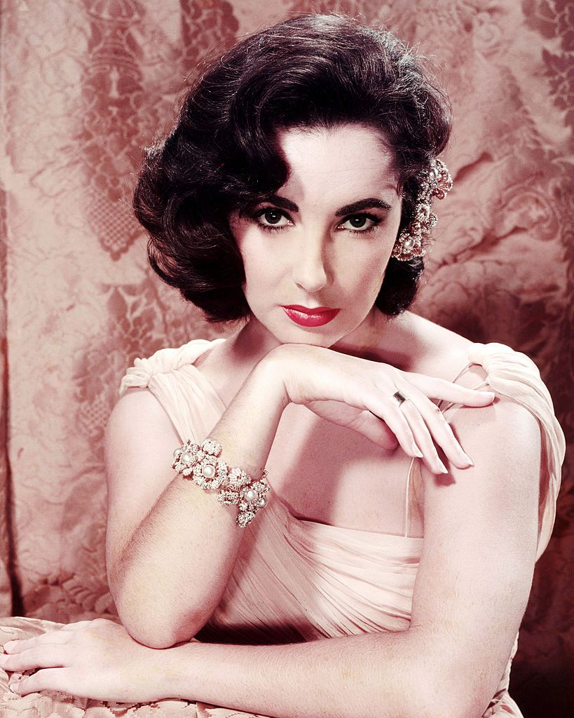 British-born American actress Elizabeth Taylor (1932 - 2011), wearing an evening gown and a pearl bracelet, circa 1955. (Photo by Silver Screen Collection/Getty Images)