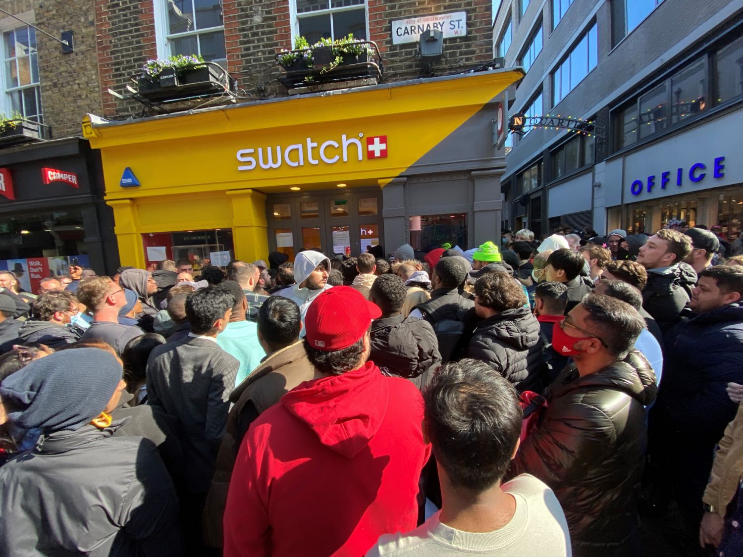 Customers congregate at the doors to the closed Swatch store on Carnaby Street, central London, after chaos broke out at the launch of the MoonSwatch, with late customers trying to barge their way into the store ahead of those who had waited in line overnight. The Omega x Swatch collaboration is a collection of solar system-inspired watches based on Omega's Moonwatch, the first wristwatch worn on the moon, but available for a fraction of the price. Picture date: Saturday March 26, 2022. (Photo by Yui Mok/PA