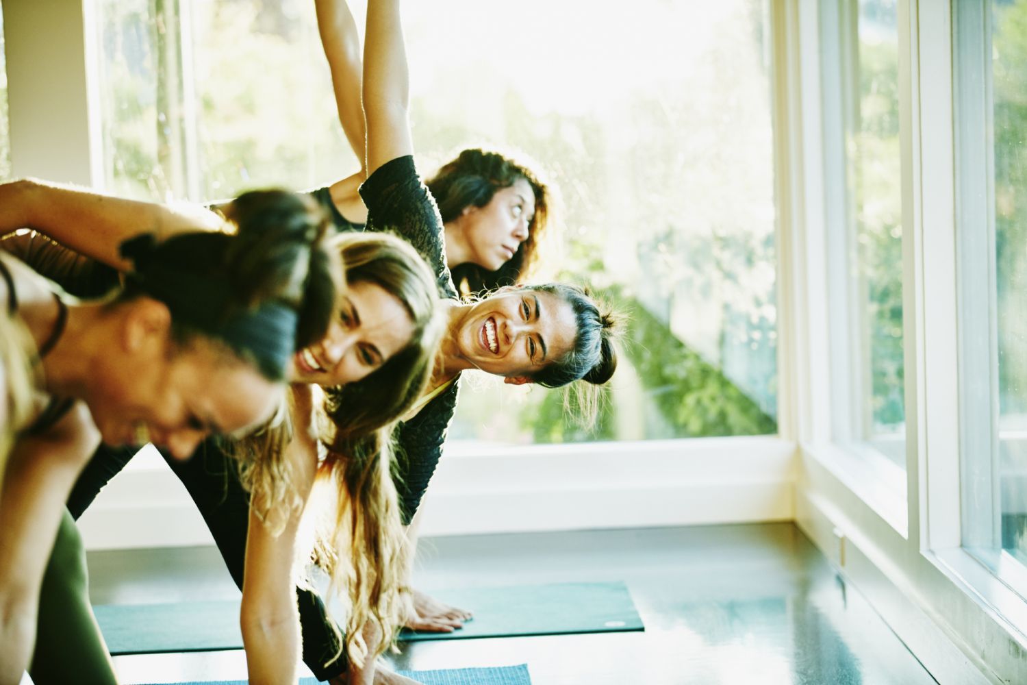 Smiling woman laughing with friends during yoga class in studio