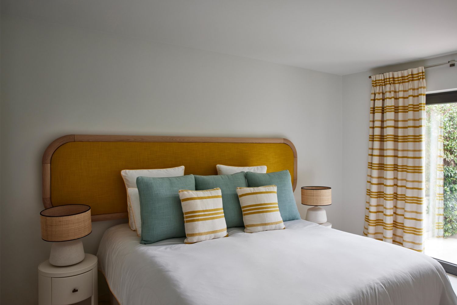 This guest bedroom features bright pops of colour that brings to mind a breezy, coastal charm