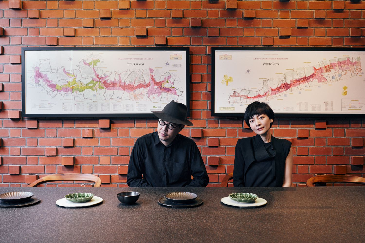 Chris Lee and Annie Li in their industrial-style dining room, which features exposed red brick and black steel columns