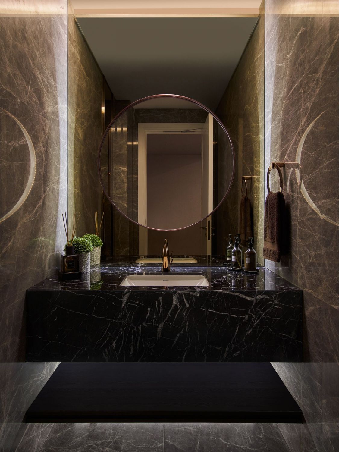 The powder room features a solid block of black marble for the basin and mirrored walls that visually expand its dimensions (Photo: Jasper Yu/Jyu Studio)