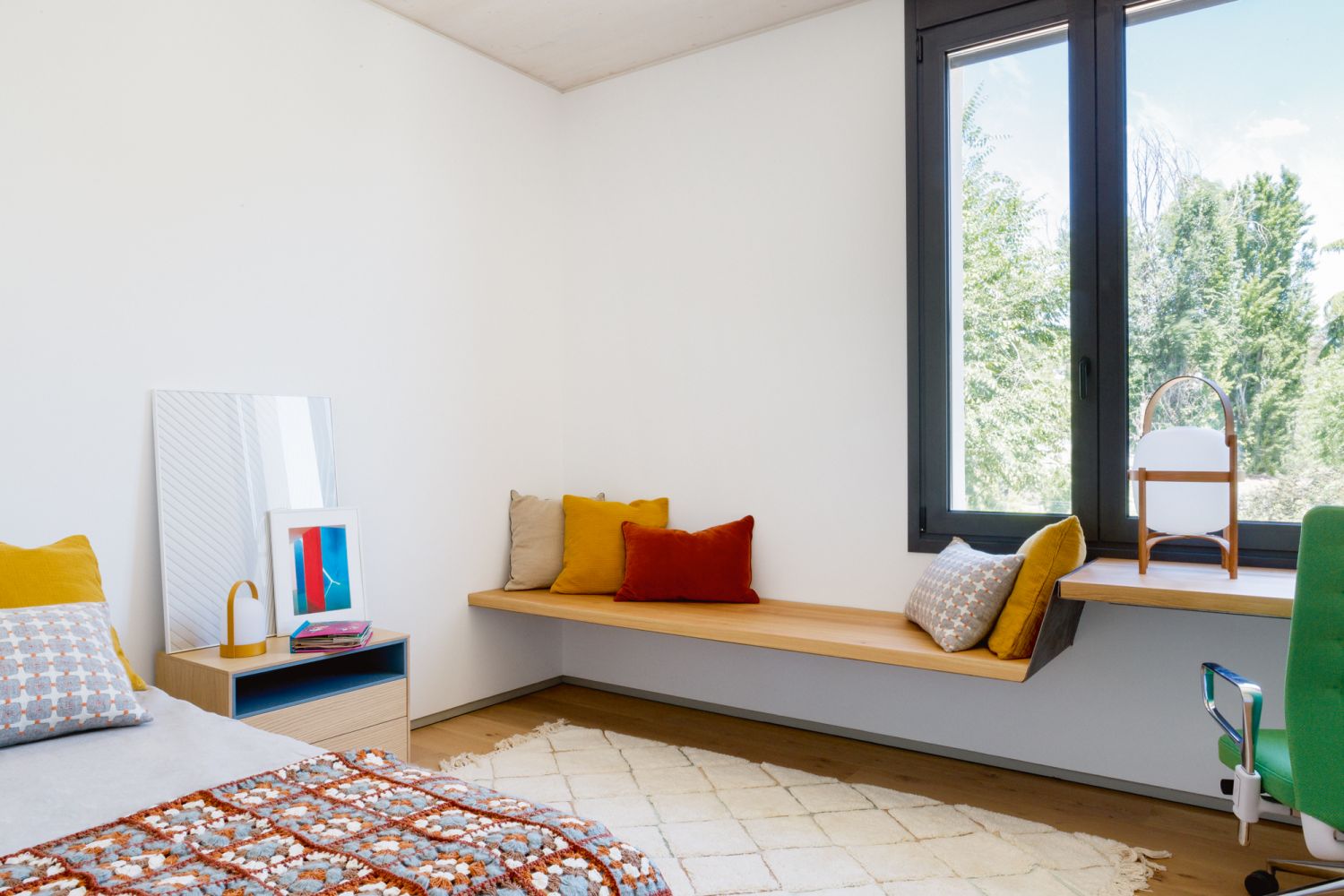 Accent cushions in warm hues and a rug contribute to the tactile look of this bedroom