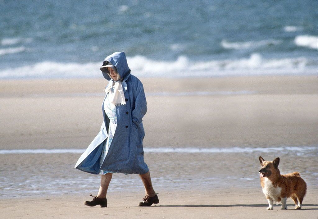UNITED KINGDOM - JULY 28: The Queen Mother Walking With One Of Her Friends And Her Corgi On The Beach In Norfolk. (Photo by Tim Graham Photo Library via Getty Images)