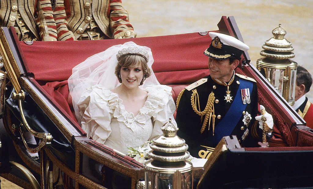 LONDON, ENGLAND - JULY 29: Prince Charles, Prince of Wales and Diana, Princess of Wales, wearing a wedding dress designed by David and Elizabeth Emanuel and the Spencer family Tiara, ride in an open carriage, from St. Paul's Cathedral to Buckingham Palace, following their wedding on July 29, 1981 in London, England. (Photo by Anwar Hussein/WireImage)
